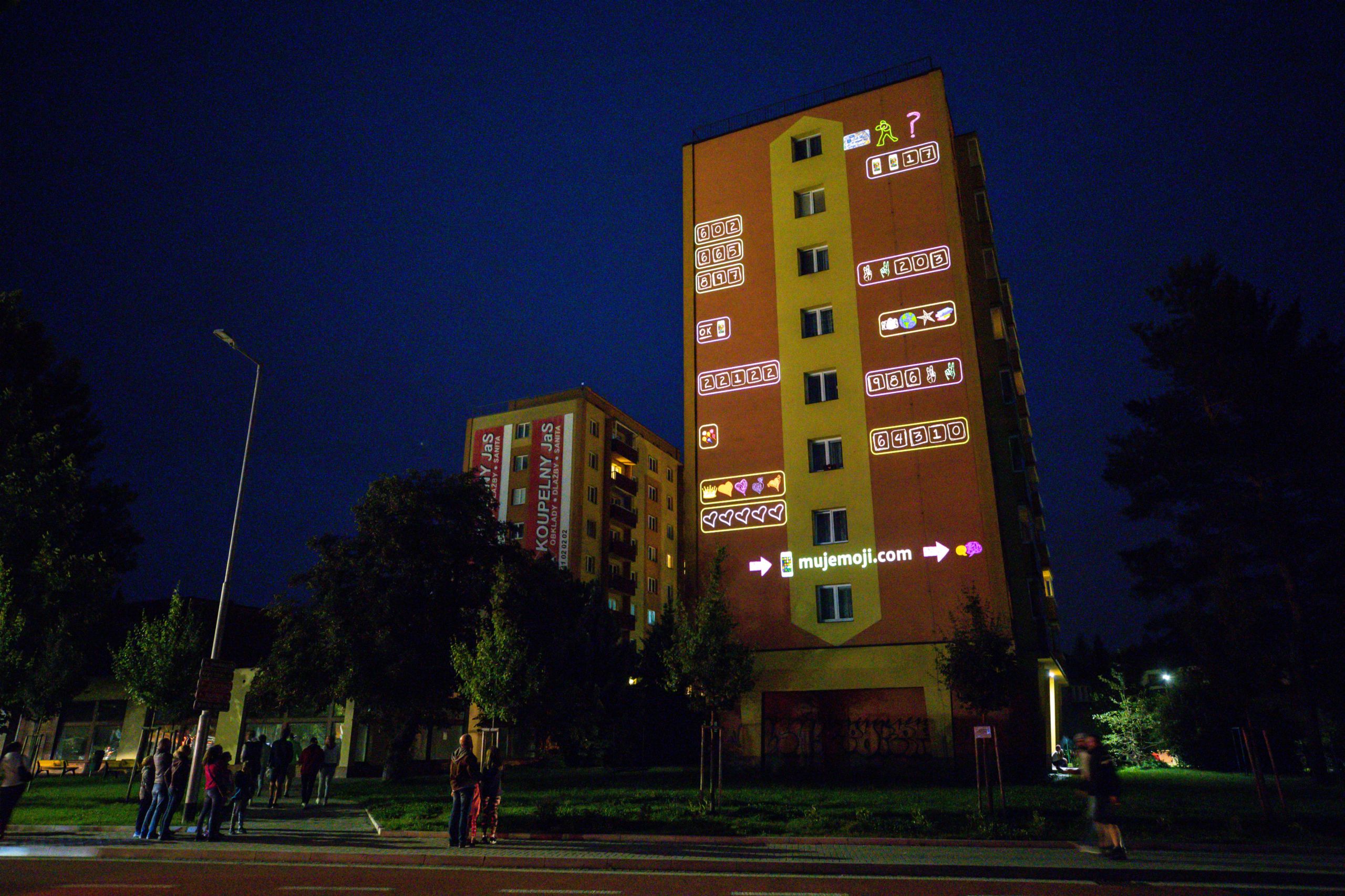 large projection of emoji chat window on building facade